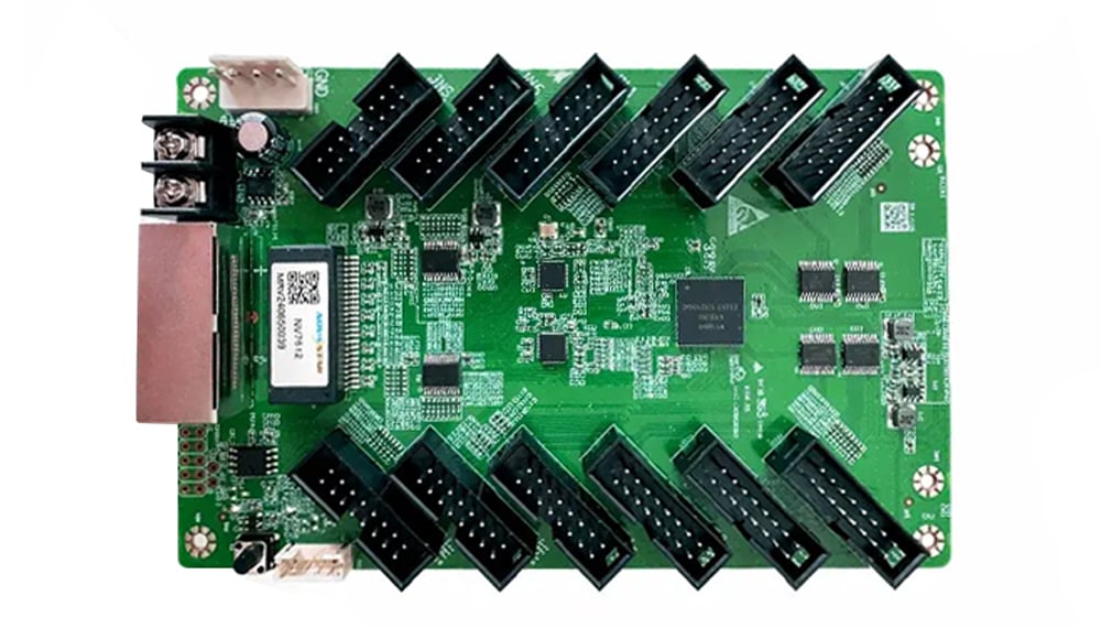 Green development PCB with numerous black edge connectors arranged around the board
