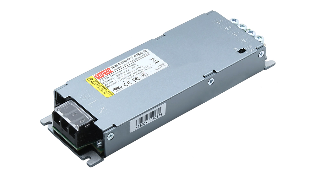 Industrial DC power supply module in a gray metal enclosure with a multigator terminal block on the right, labeled V+ and V-